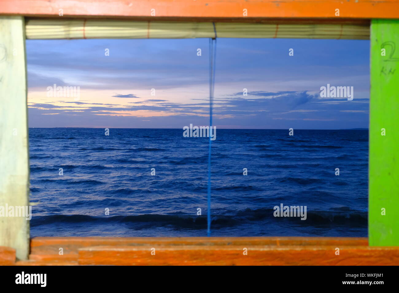 Colorful ocean view window with wooden frame Stock Photo