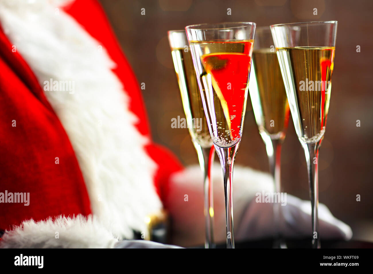 Santa Claus holding champagne glasses on the tray. Closeup Stock Photo