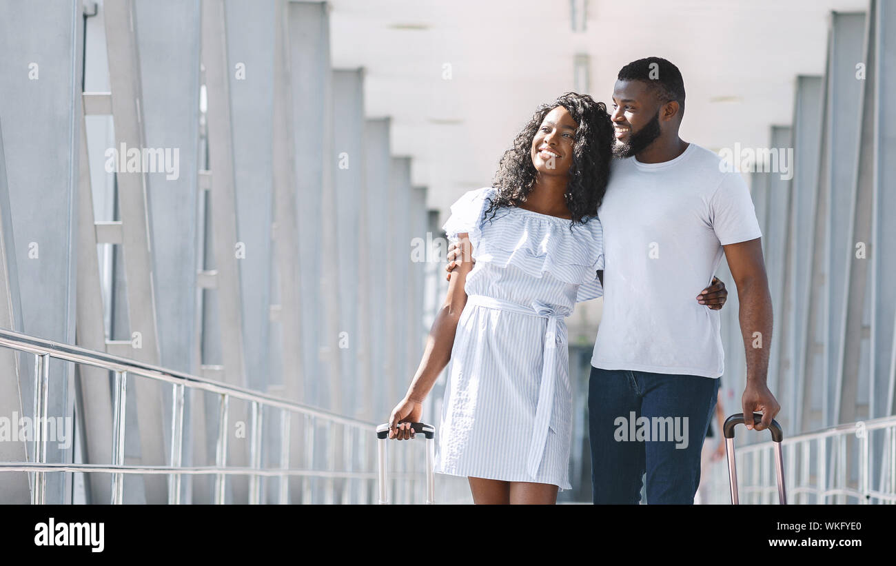 Happy african couple going in airport terminal with luggage Stock Photo ...
