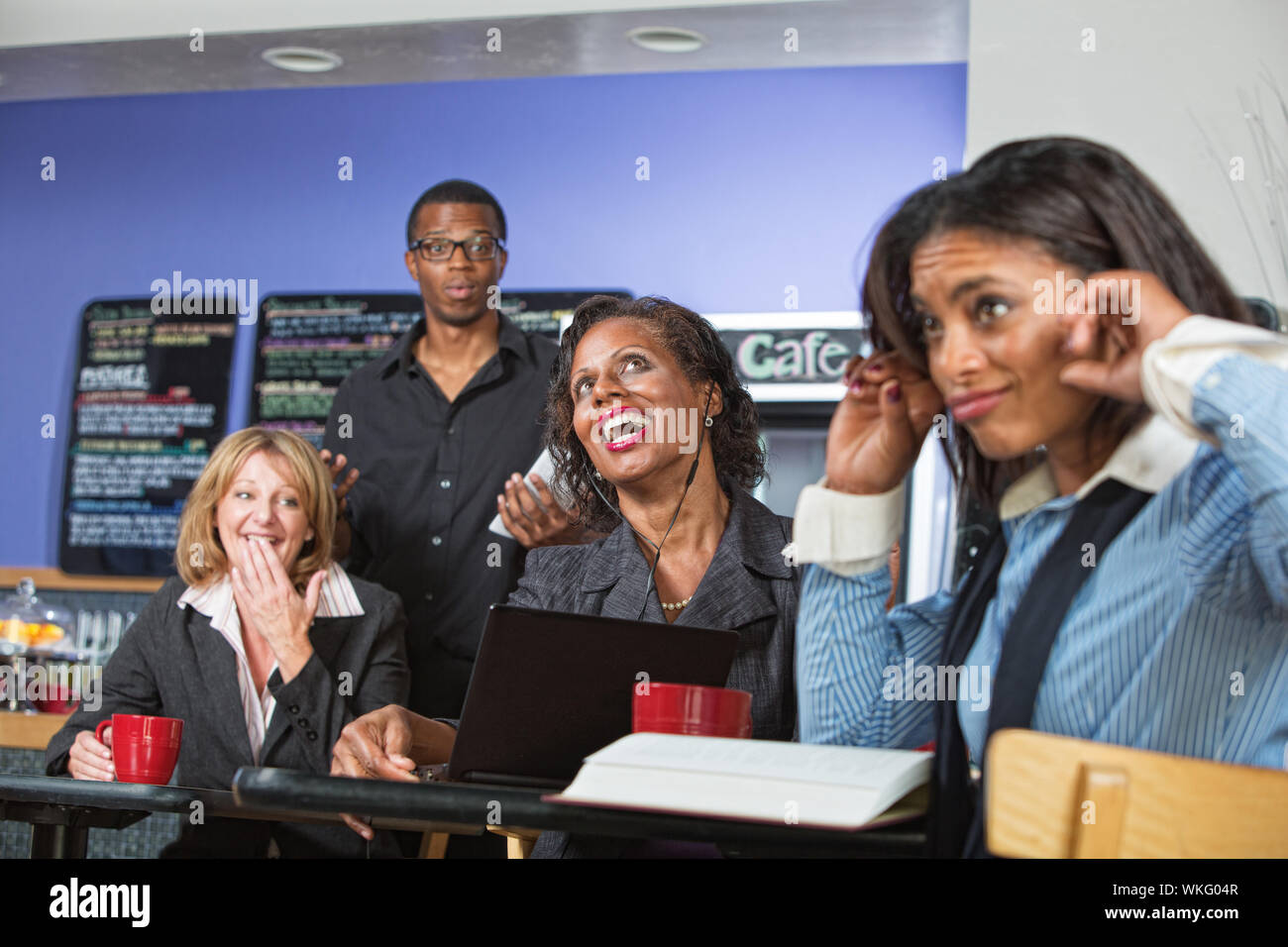 Annoyed customers covering ears with woman singing out loud Stock Photo