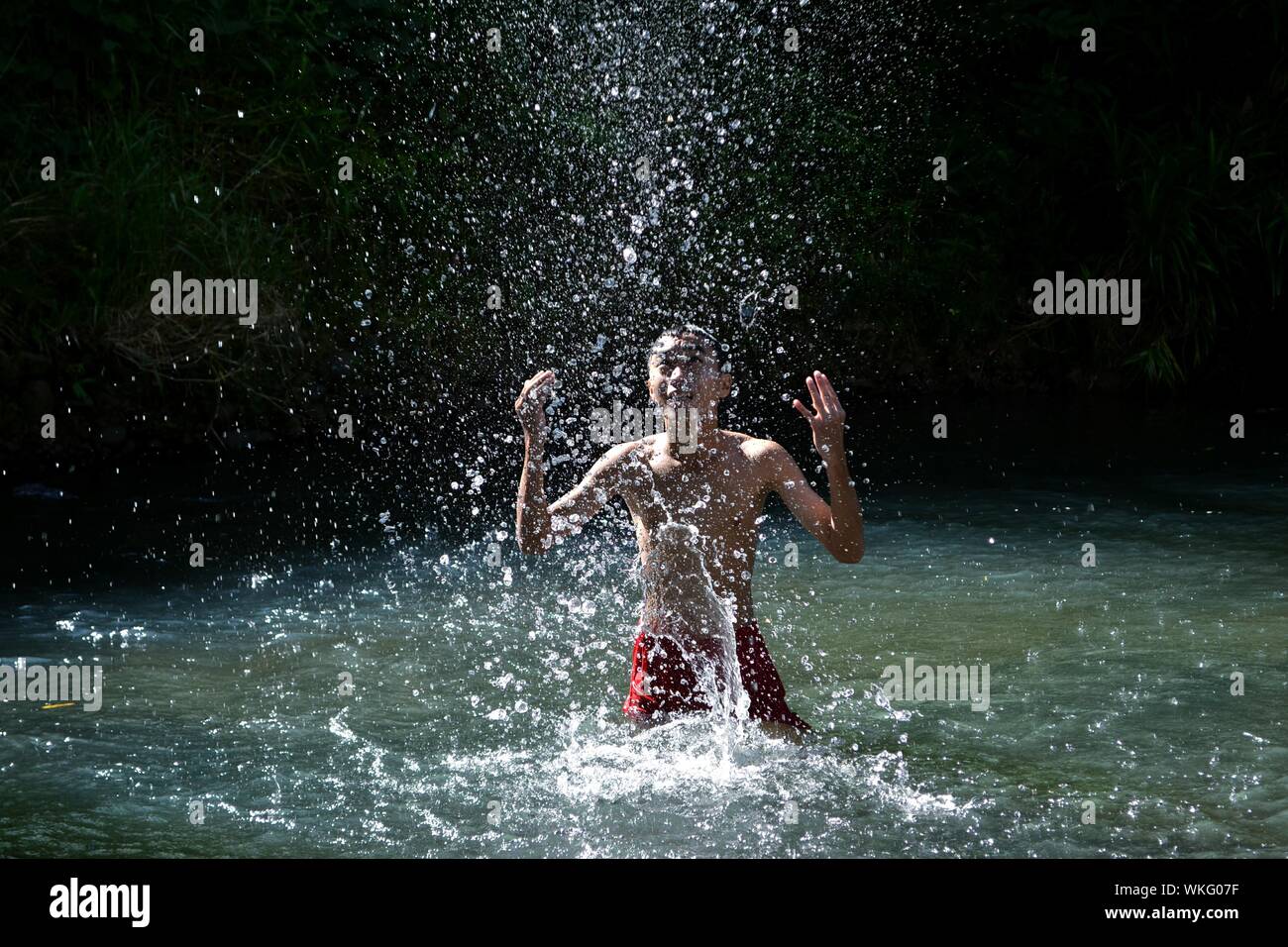 Boy splashing in water hi-res stock photography and images - Alamy
