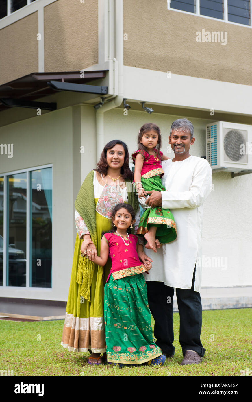 Beautiful Asian Indian family portrait smiling outside their new house