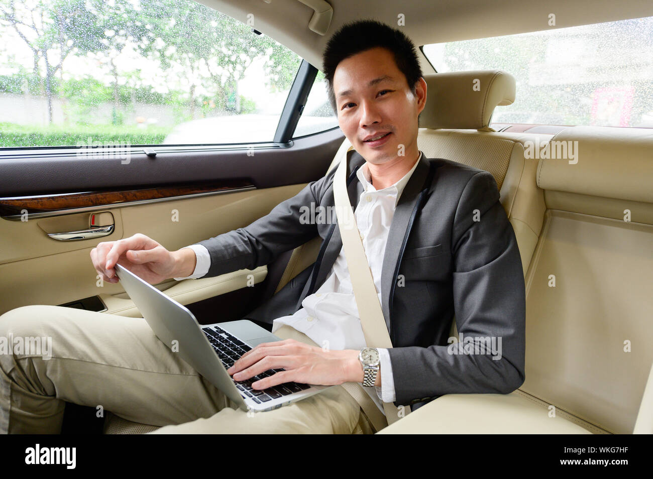 Successful young man using laptop while sitting in car Stock Photo