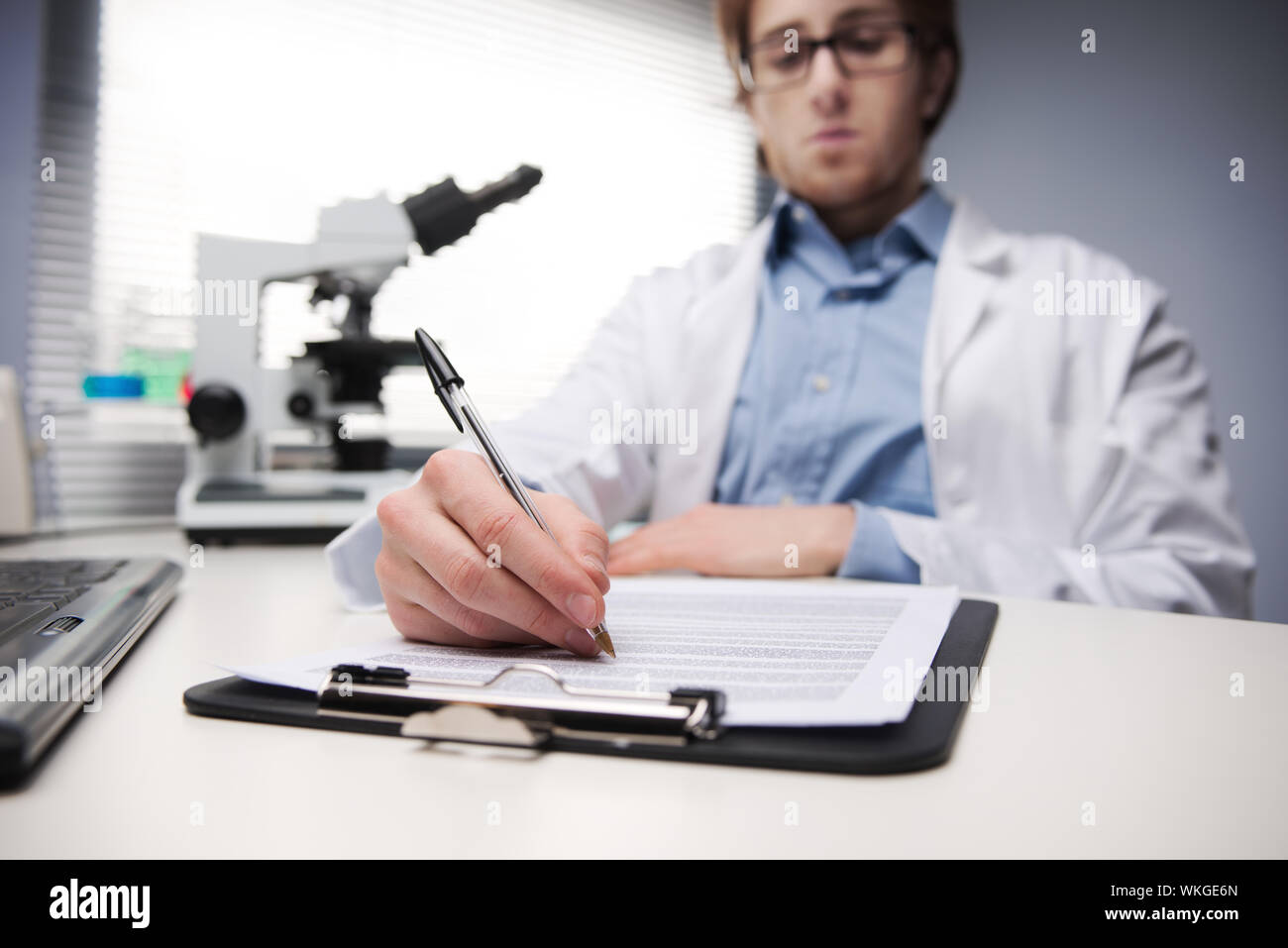 Person Writing Lab Notes Young researcher writing notes at desk in the chemical lab Stock Photo ...