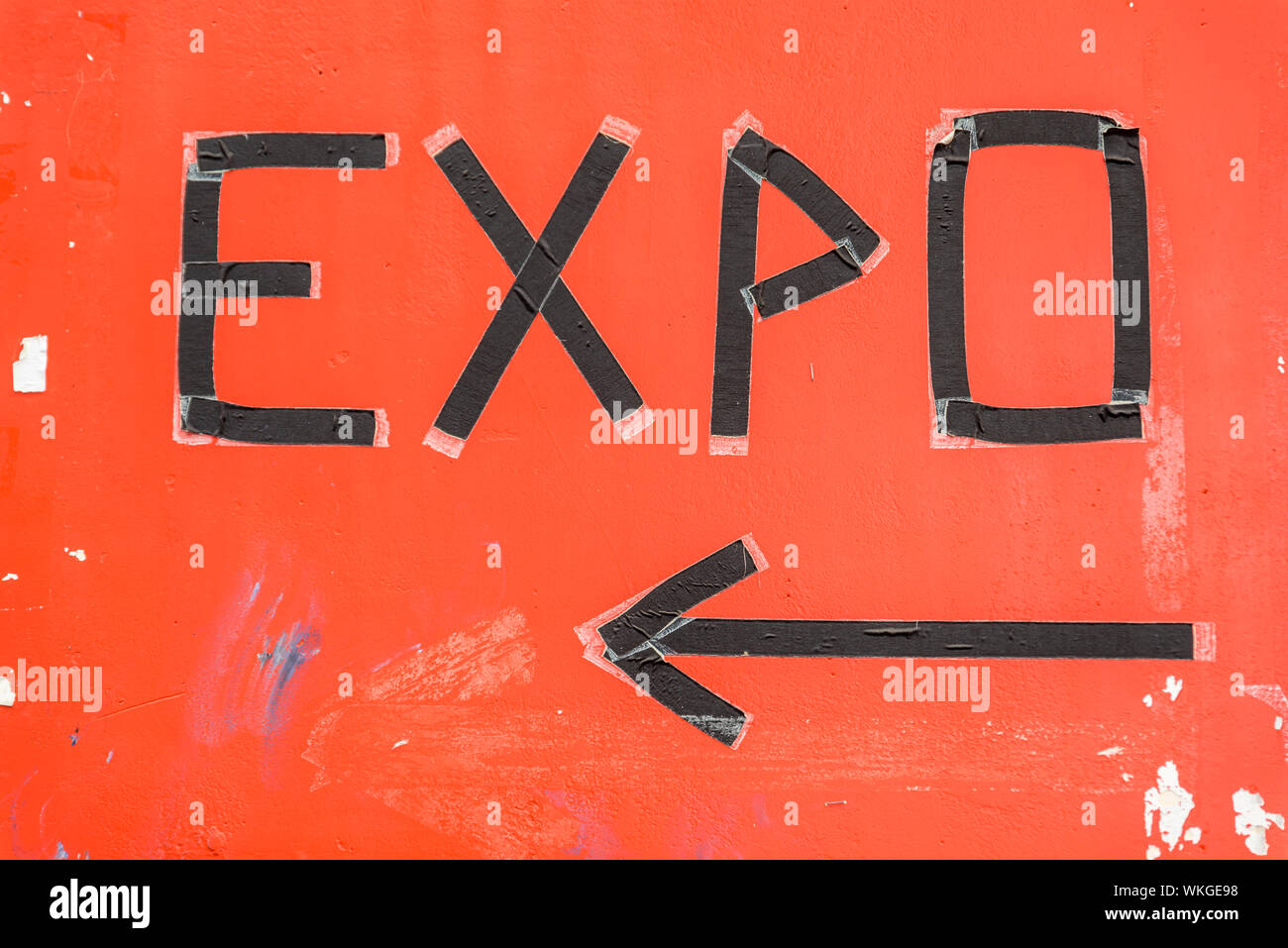 expo sign made of black isolation tape on a worn down orange background Stock Photo