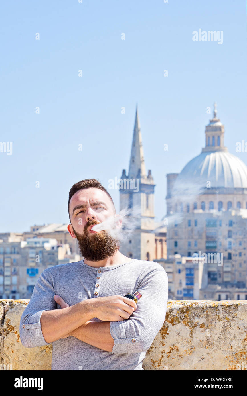 Man standing cigarette crossed arms hi-res stock photography and images