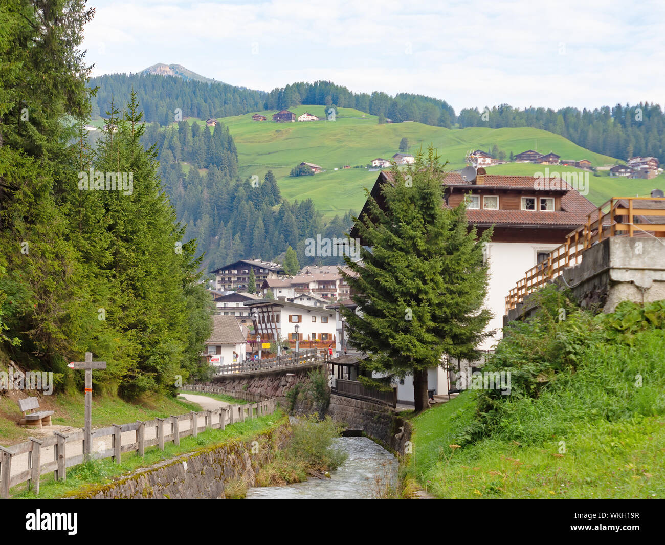 VAL DI GARDENA, ITALY - SEPTEMBER 1, 2019: View as you walk into Selva Val di Gardena in Alto Adige, by river with Dolomites behind. Stock Photo