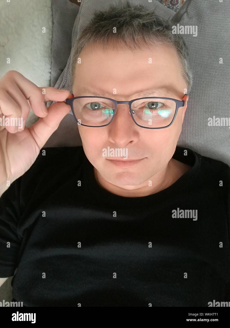 Portrait Of Man Wearing Eyeglasses Lying Down On Bed Stock Photo - Alamy