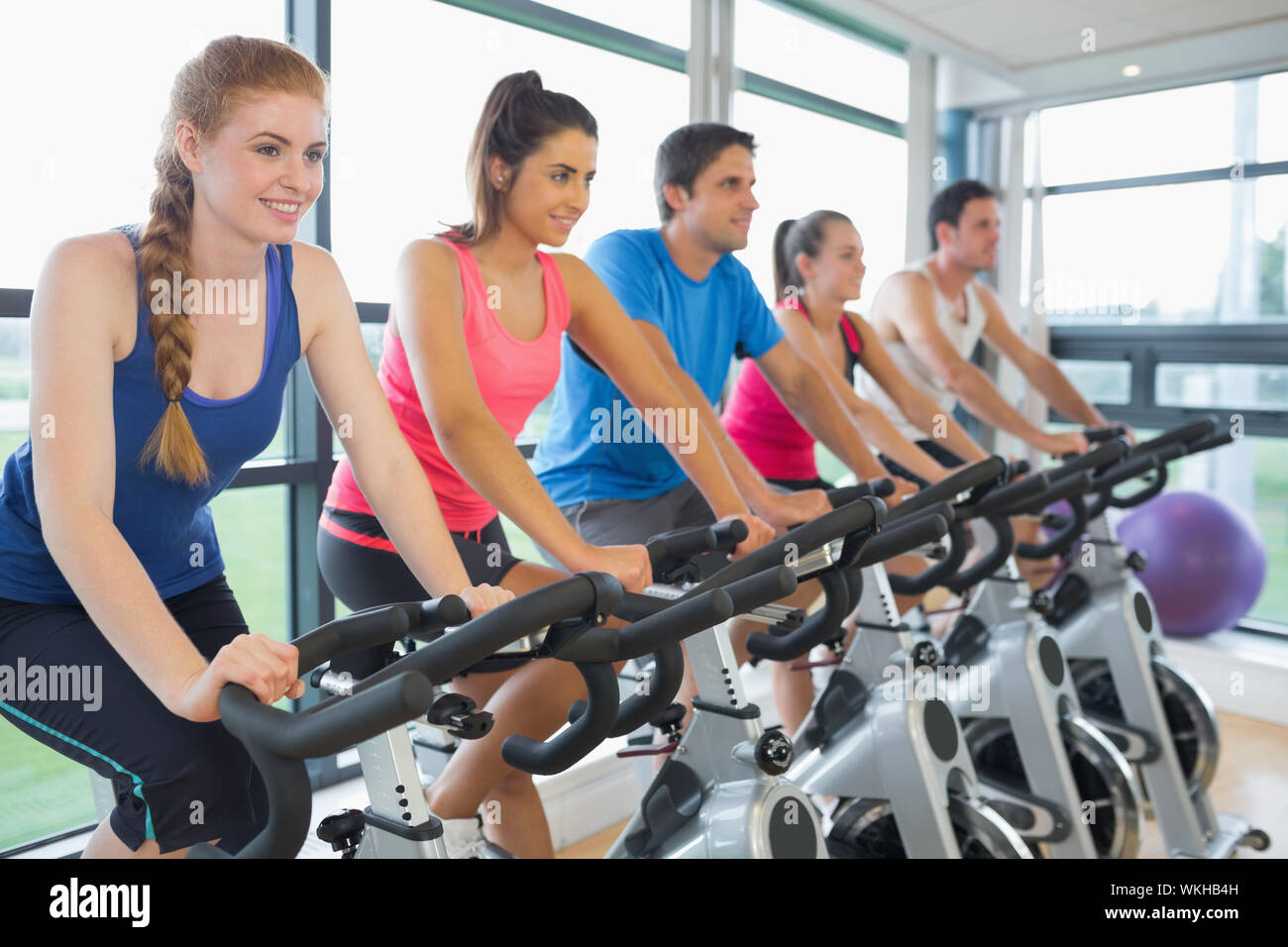 Determined five people working out at spinning class in gym Stock Photo ...