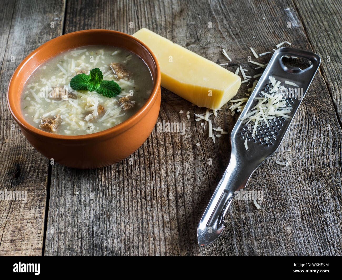 Close-up Of Vegetable Soup With Croutons And Grated Cheese On Wooden Table Stock Photo