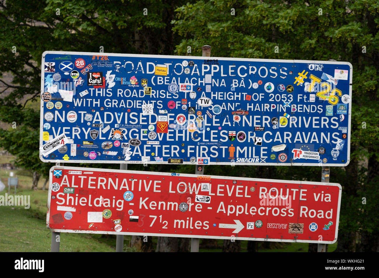 Road sign covered in stickers at foot of Applecross pass on the North Coast 500 tourist motoring route in northern Scotland, UK Stock Photo