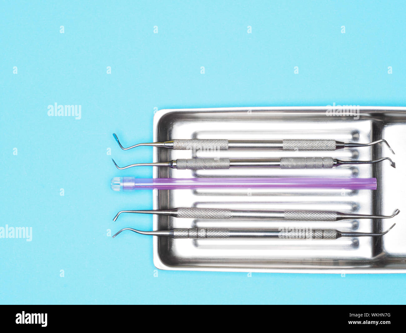 Dental instrument in tray on blue background with copy space. Dental