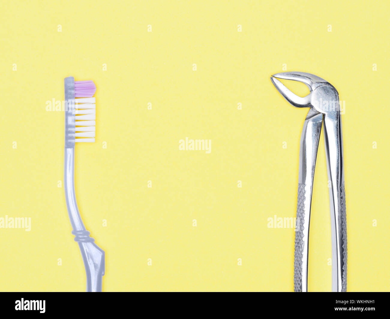 Dental surgical instrument and toothbrush on yellow background with copy space. Dental care concept Stock Photo