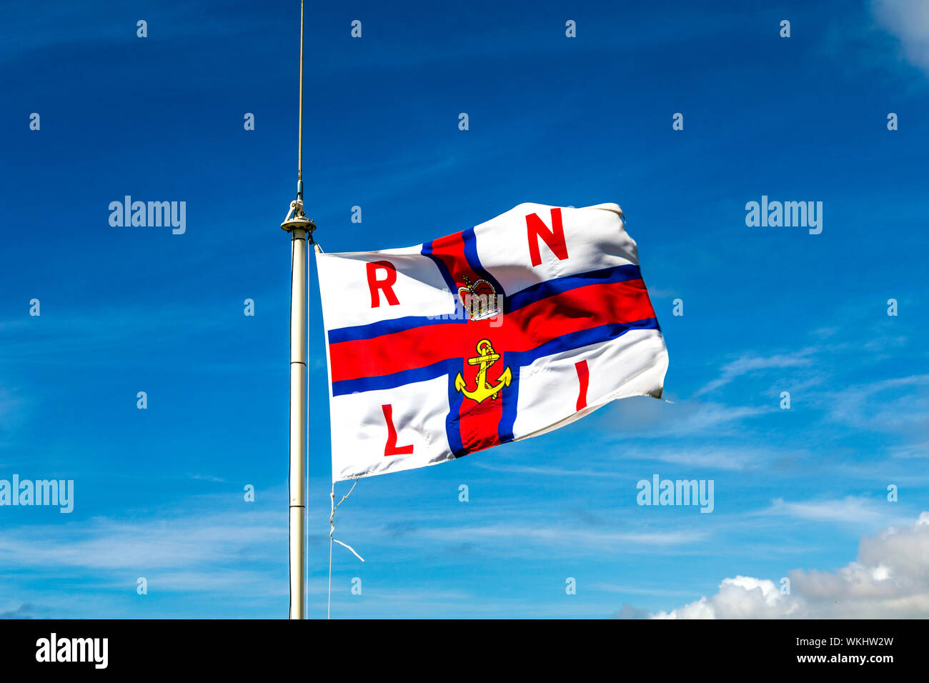 RNLI (Royal National Lifeboat Institution) flag fluttering in the wind Stock Photo