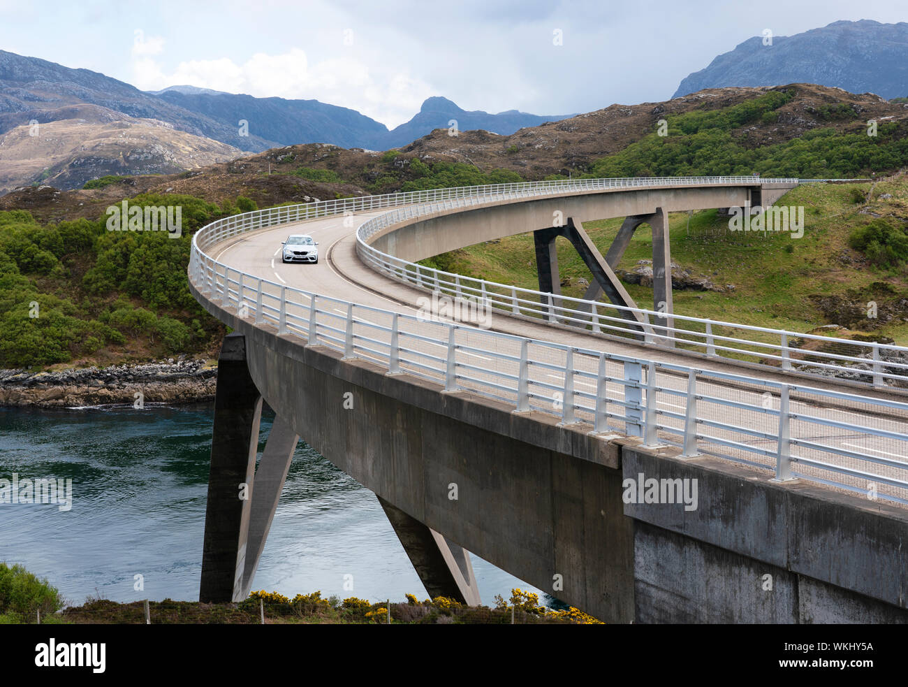 Car driving on the Kylesku Bridge on the North Coast 500 tourist motoring route in northern Scotland, UK Stock Photo