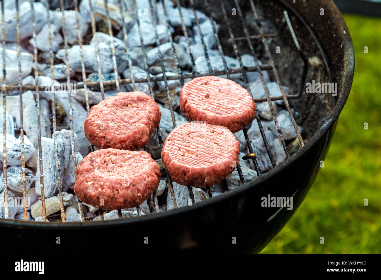 Raw hamburger patties on the grill Stock Photo - Alamy