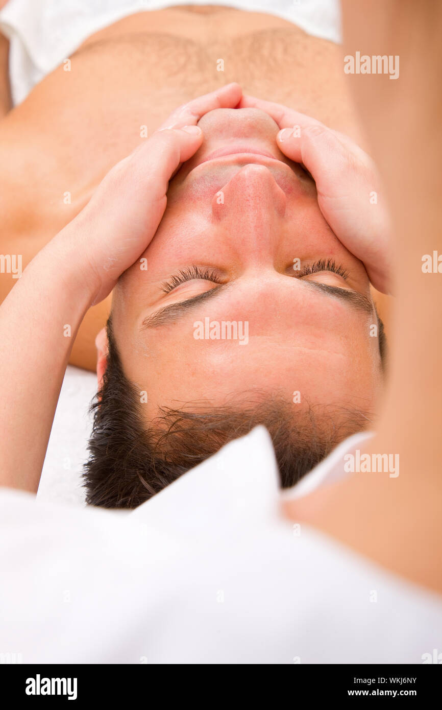 Close-up of young man getting face massage Stock Photo