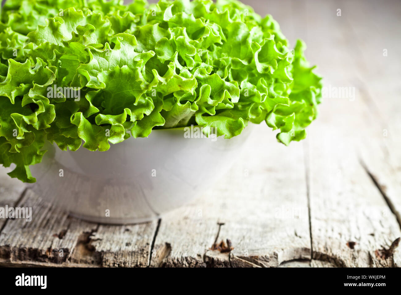 lettuce salad in a bowl closeup on rustic wooden table Stock Photo - Alamy