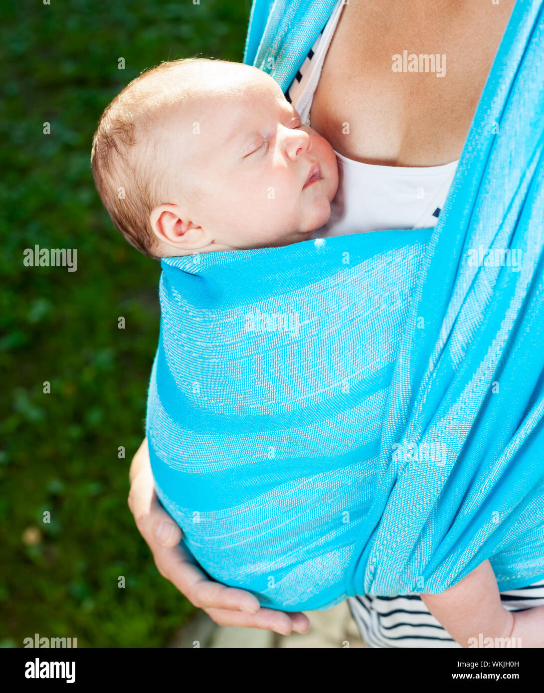 Mother carrying her child in a baby sling Stock Photo Alamy