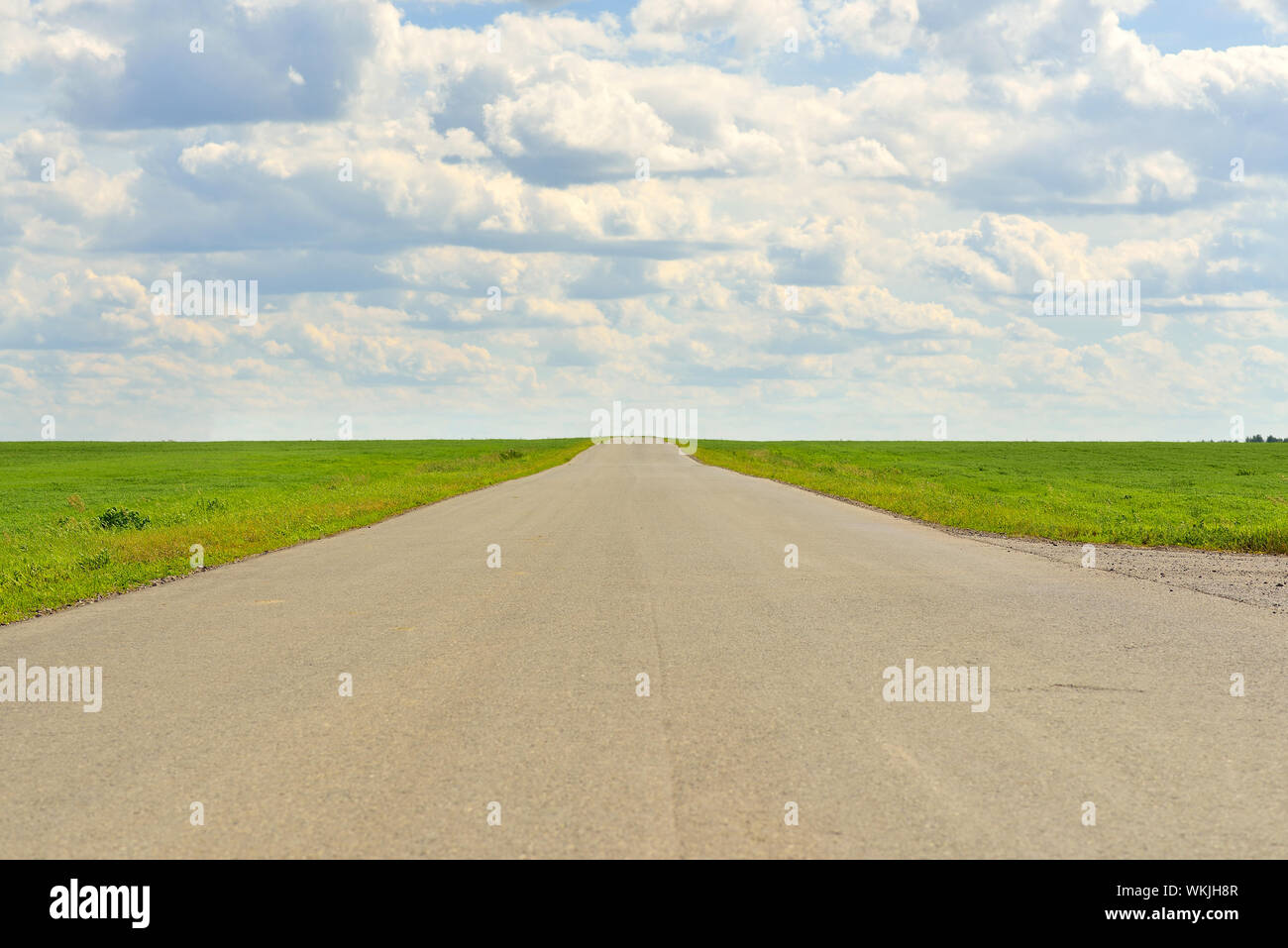 Summer landscape with green grass, road and clouds Stock Photo - Alamy