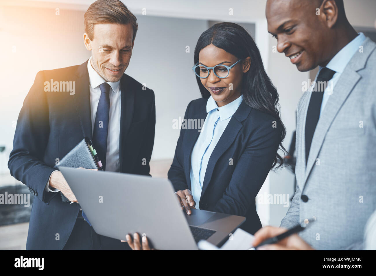 Diverse group of smiling businesspeople standing in a bright modern ...