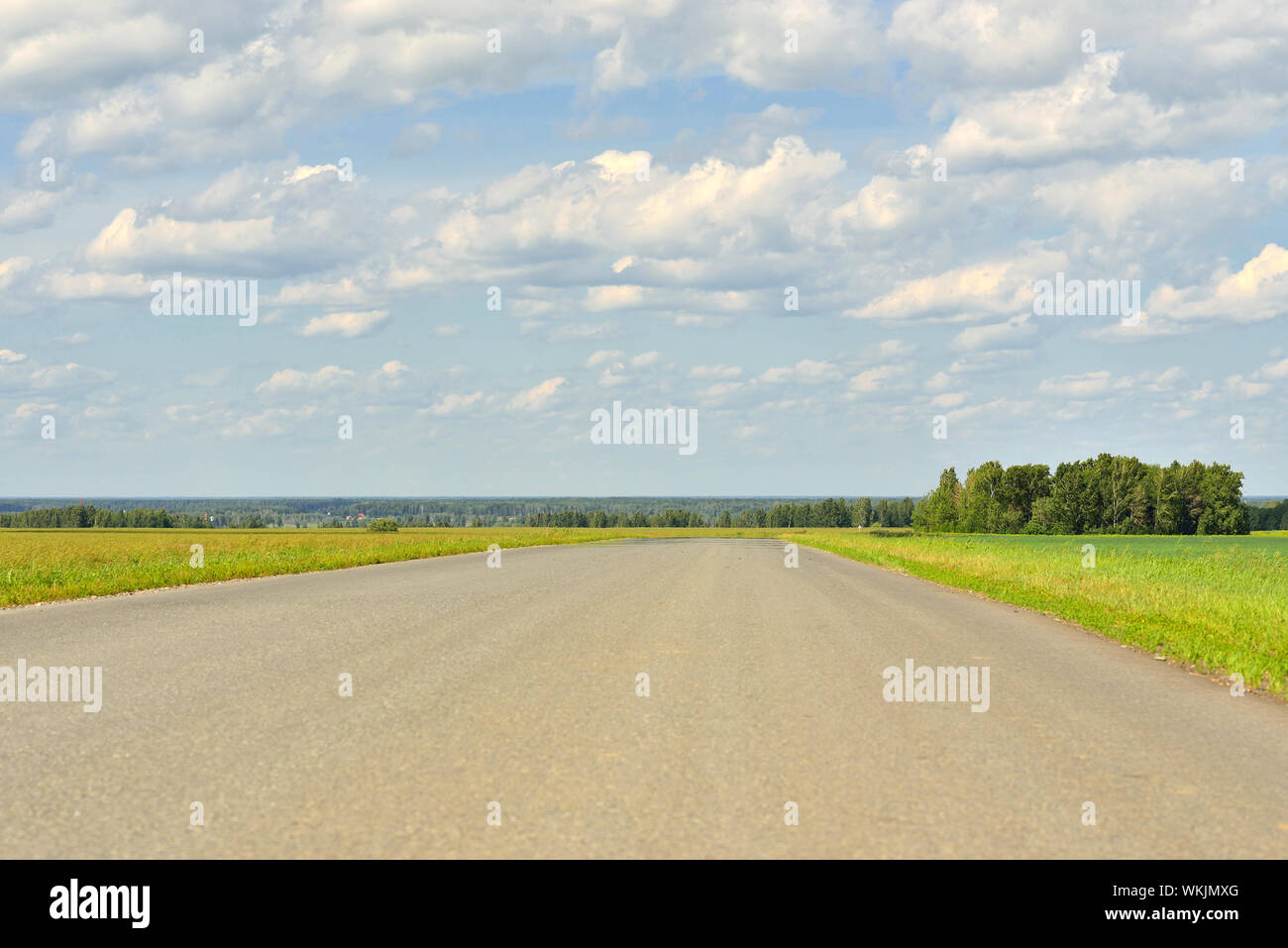 Summer landscape with green grass, road and clouds Stock Photo - Alamy