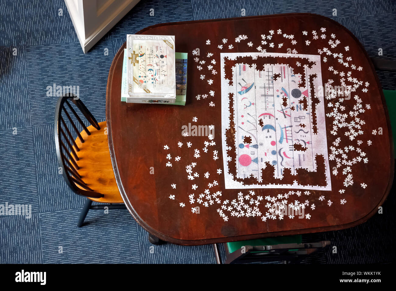 Unsolved jigsaw puzzle on a wooden table. Stock Photo