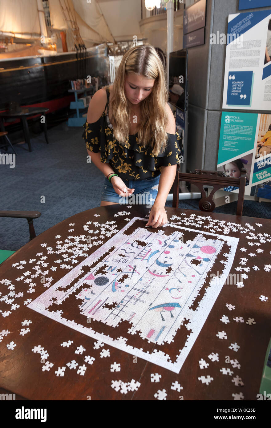 Unsolved jigsaw puzzle on a wooden table. Stock Photo