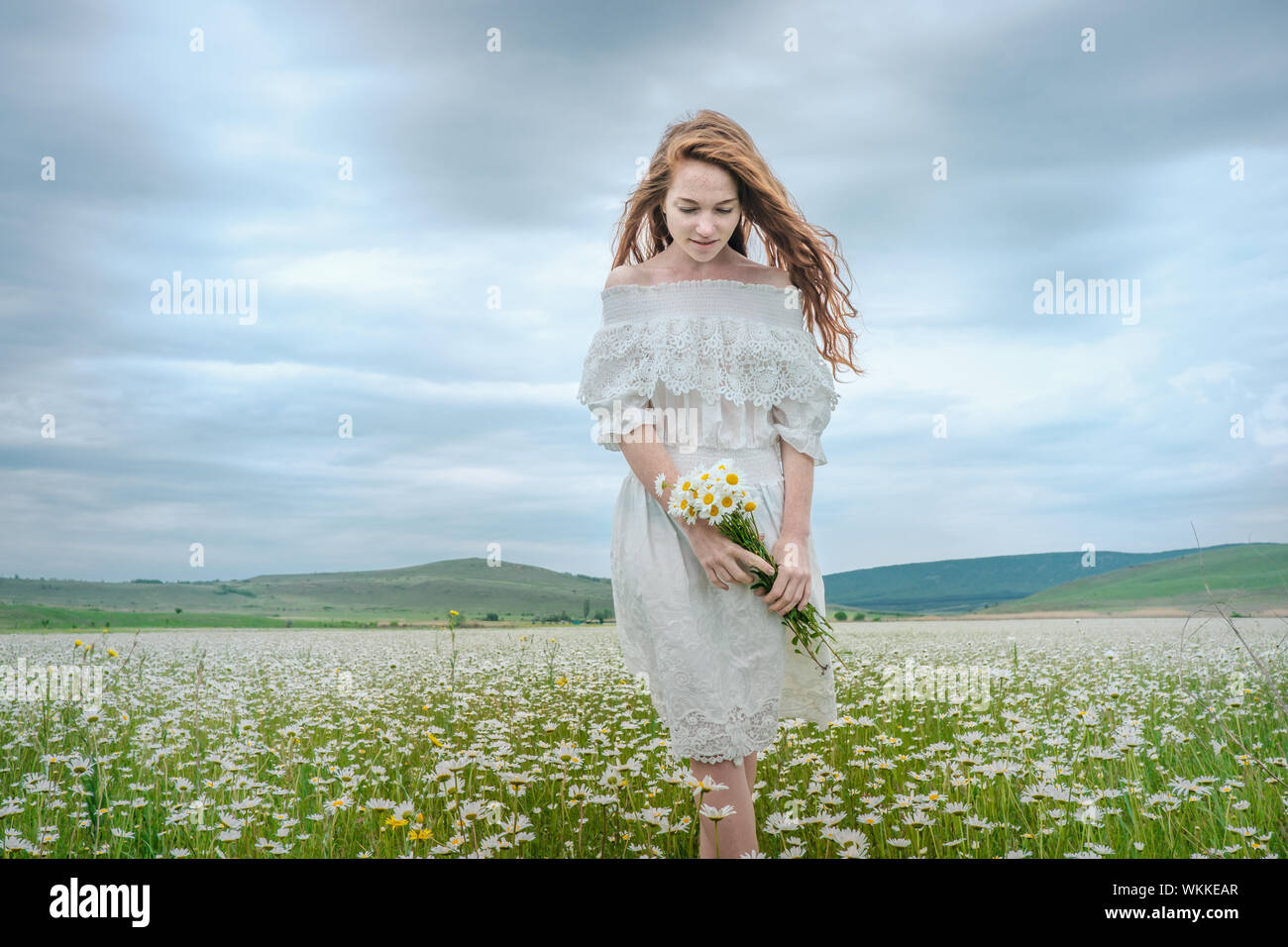 Beautiful Young Girl With Curly Red Hair In Chamomile Field