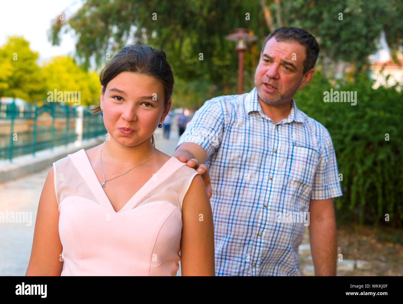 Father Consoling Daughter While Standing On Street Stock Photo