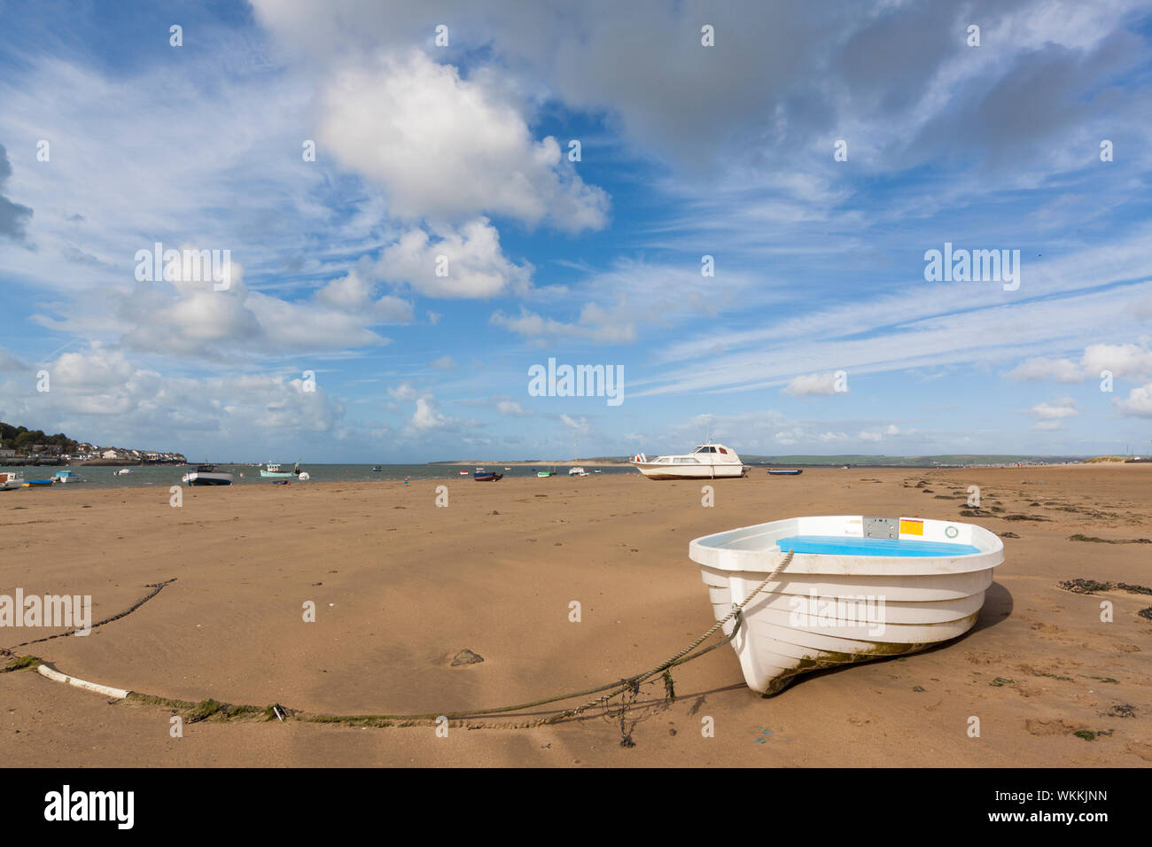 boats rest on the sand at instow beach, north devon during low tide on a sunny day Stock Photo