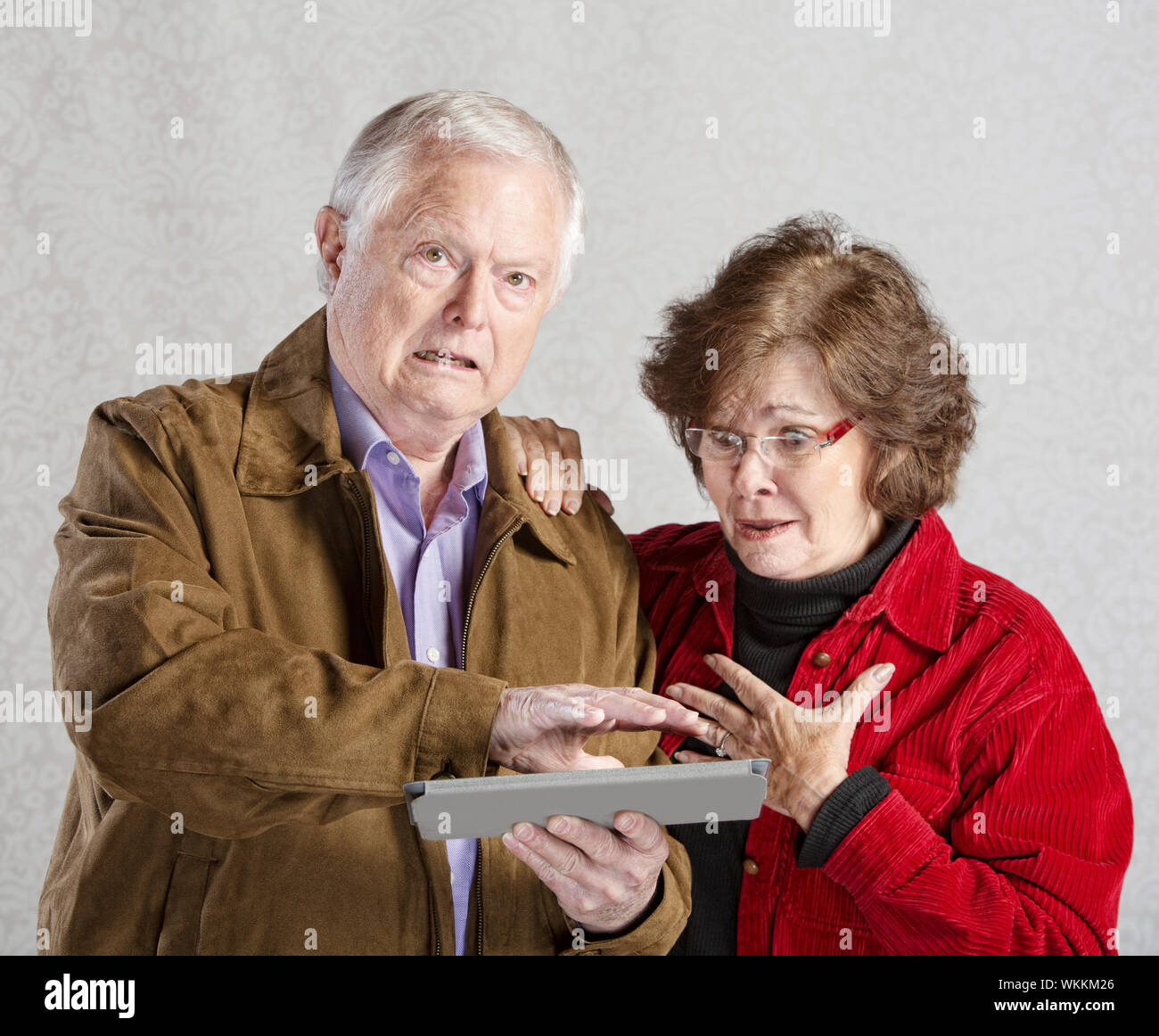 Embarrassed senior man covering his tablet computer Stock Photo - Alamy