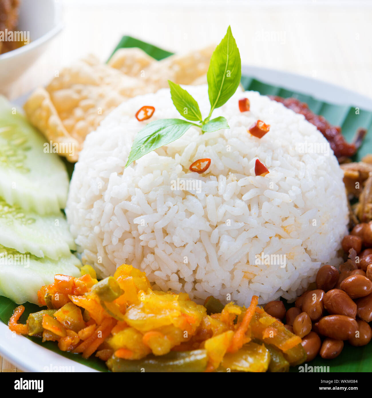 Nasi lemak kukus traditional malaysian spicy rice dish. Served with belacan, ikan bilis, acar, peanuts and cucumber. Stock Photo
