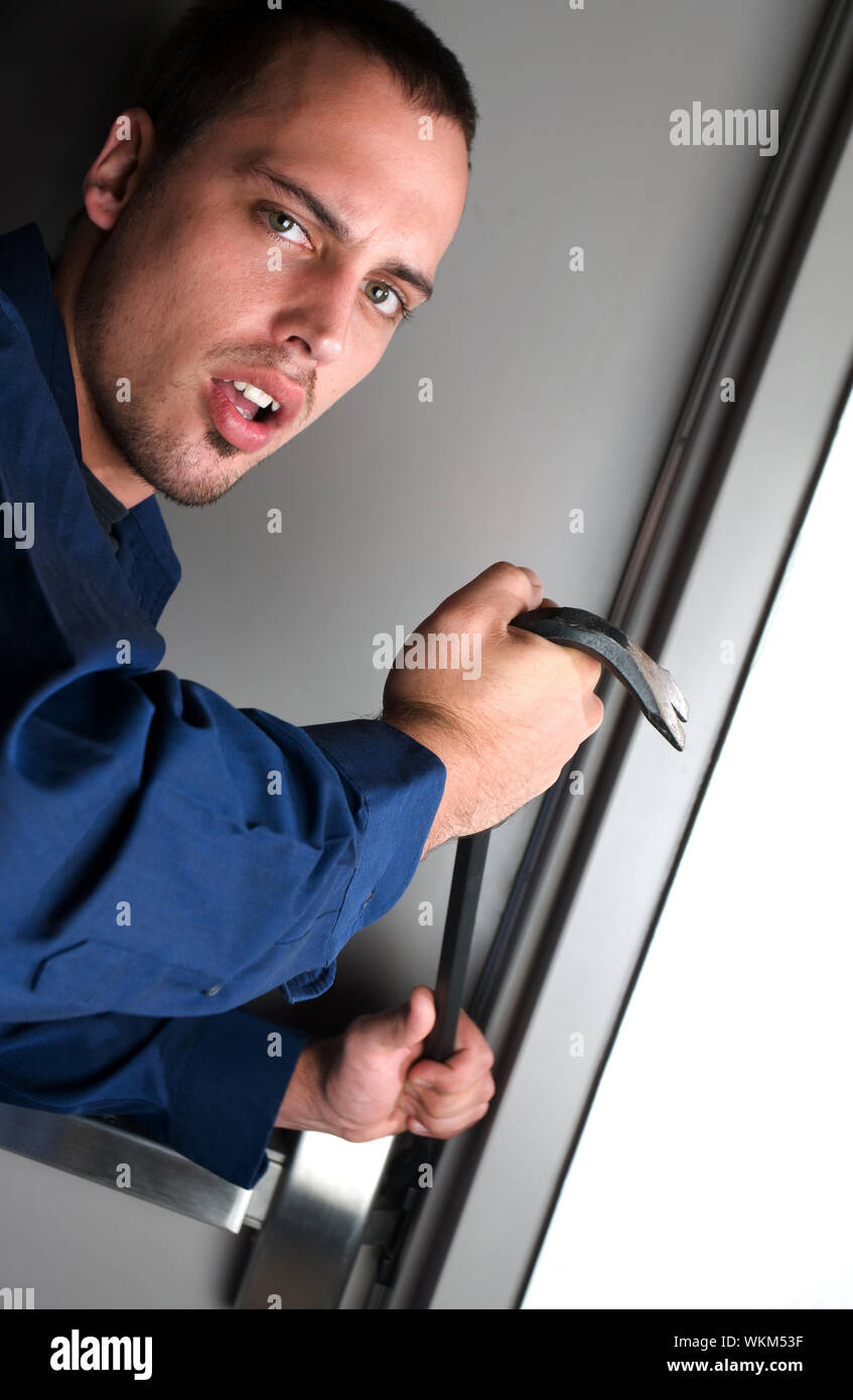 Burglar Breaking Into A Building Using Crowbar Stock Photo - Alamy