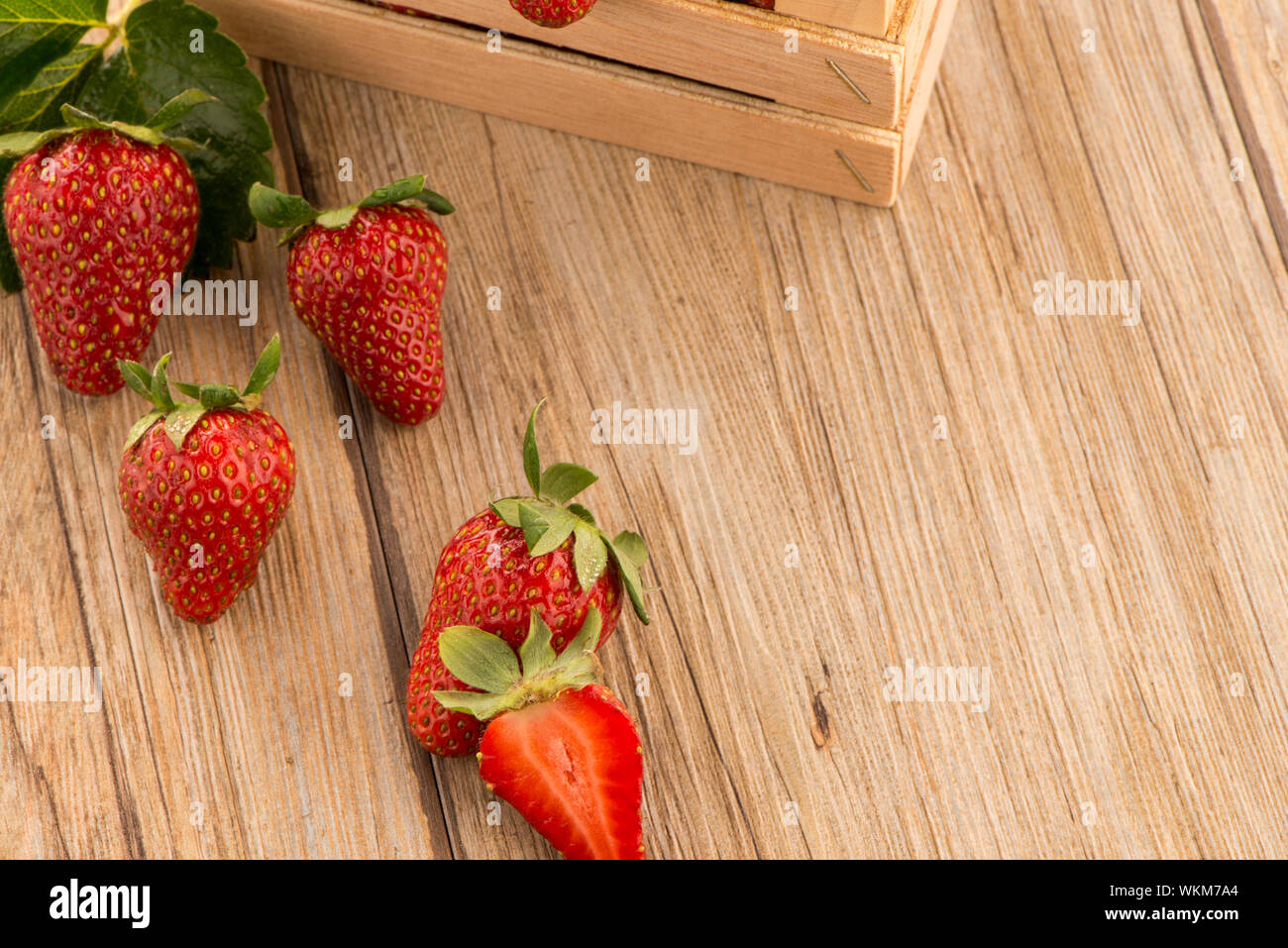 Strawberries over odl brown wooden table background Stock Photo - Alamy