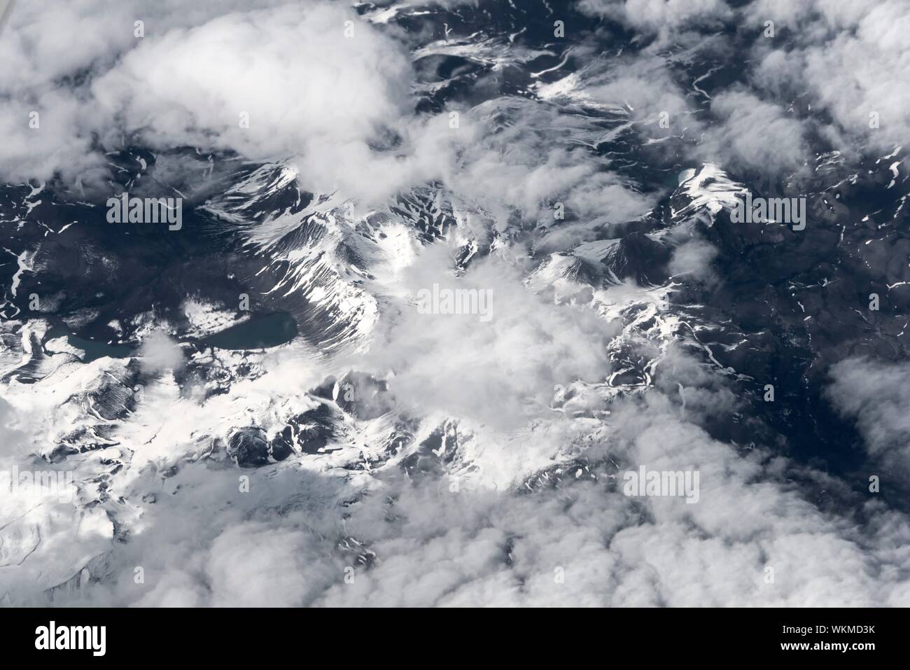 View from the plane to a snow-covered landscape with mountains and clouds, bird's eye view, Iceland Stock Photo