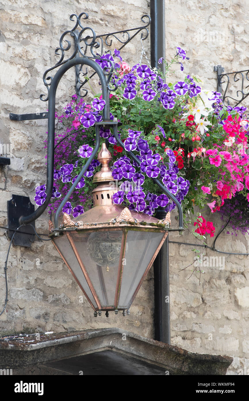 Old fashioned lamp and a floral hanging basket outside the Black horse pub. Cirencester, Cotswolds, Gloucestershire, England Stock Photo