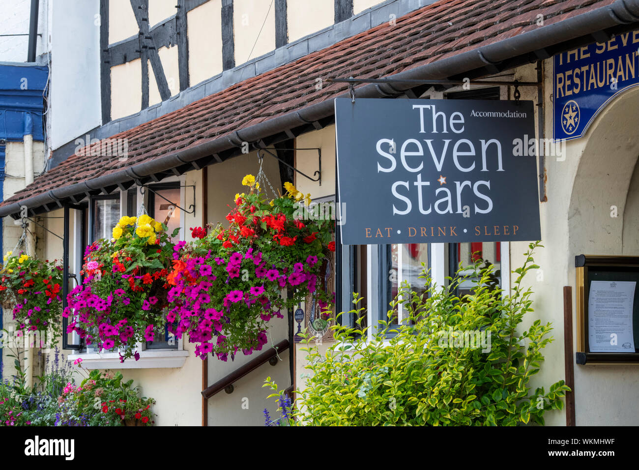 Floral hanging baskets outside The Severn Stars Inn. 16th century timber framed period building. Ledbury Herefordshire. England Stock Photo