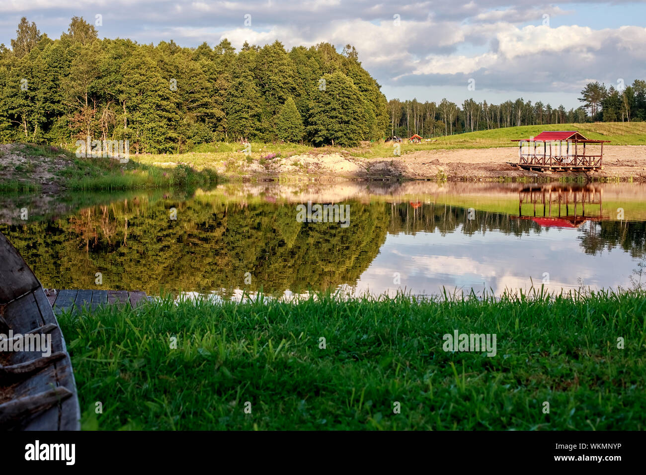 Rest zone. Blue water in a forest lake with pine trees. The forest is ...