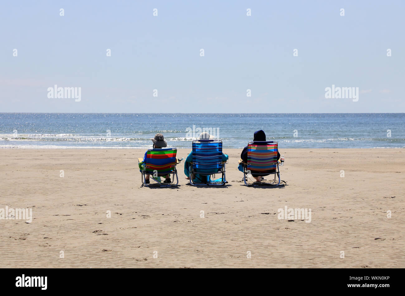 People relaxing on Higgins Beach during low tide hour.Scarborough.Maine