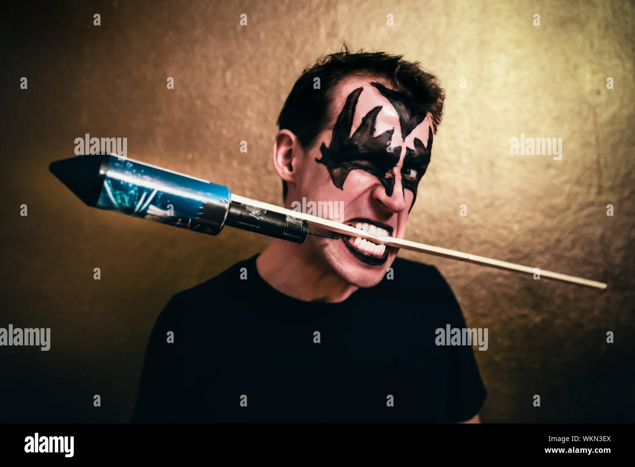 Portrait Of Man With Face Paint Carrying Explosive Material In Mouth Stock Photo