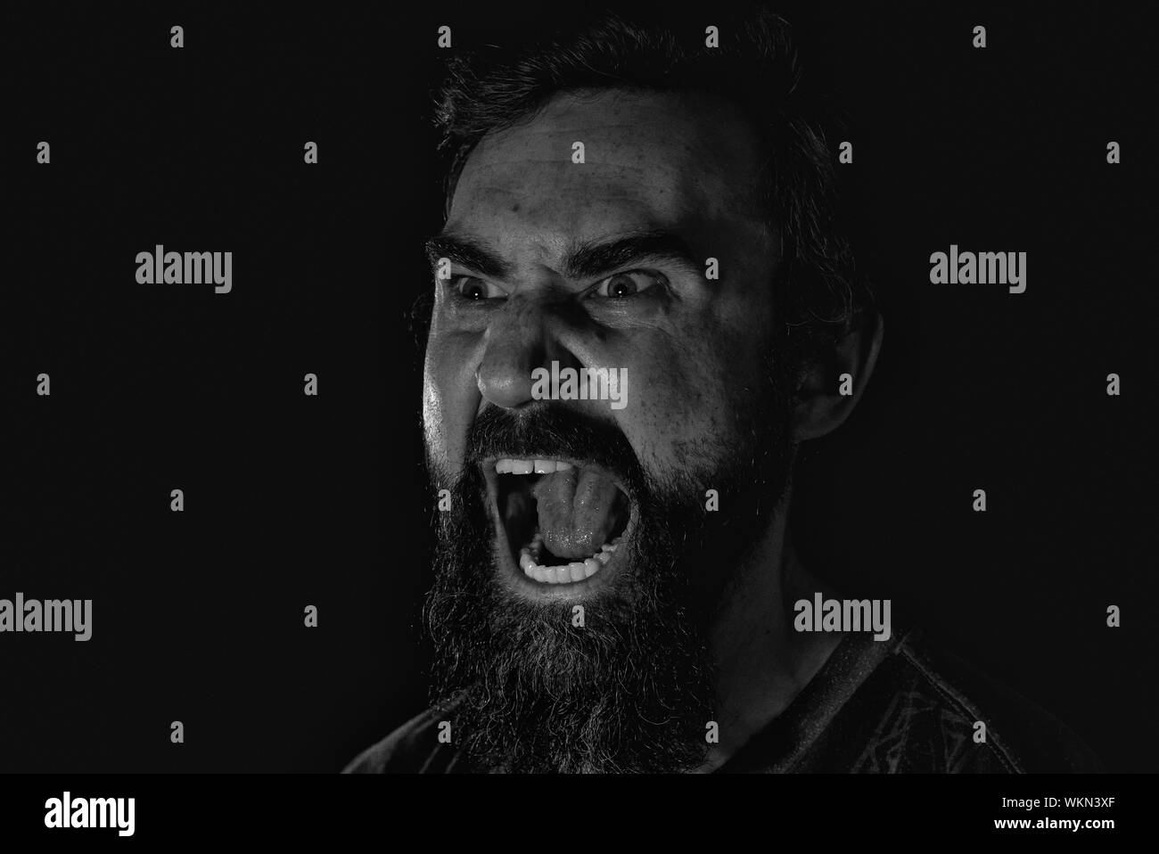 Close-up Of Angry Man Shouting Against Black Background Stock Photo