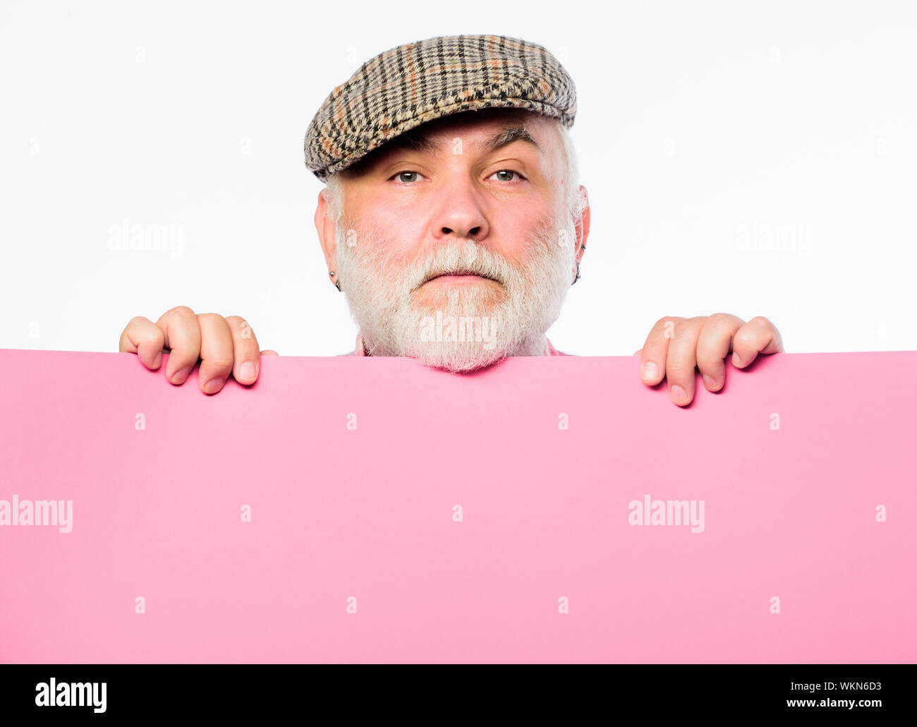 Announcement concept. Pensioner hold poster information copy space. Weekend entertainment. Senior bearded man peeking out of banner place information. Public information. Advertisement elderly people. Stock Photo