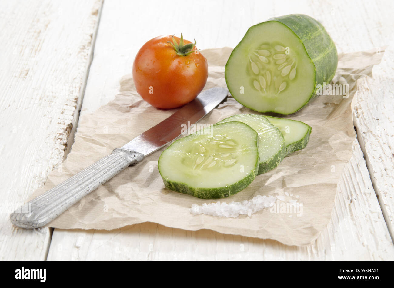 sliced ​​cucumber, salt and a tomato on brown paper Stock Photo