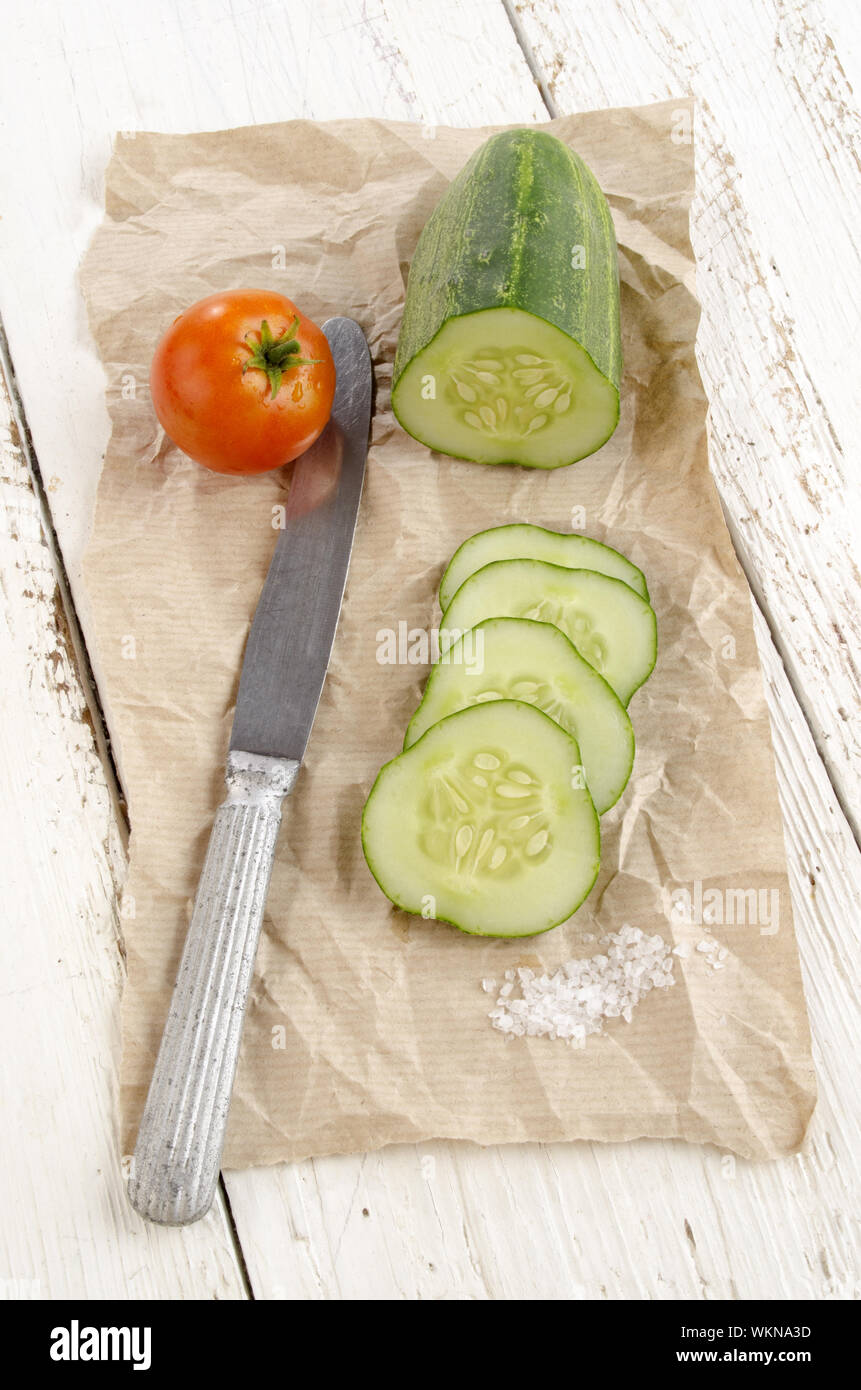 sliced ​​cucumber, salt and a tomato on brown paper Stock Photo