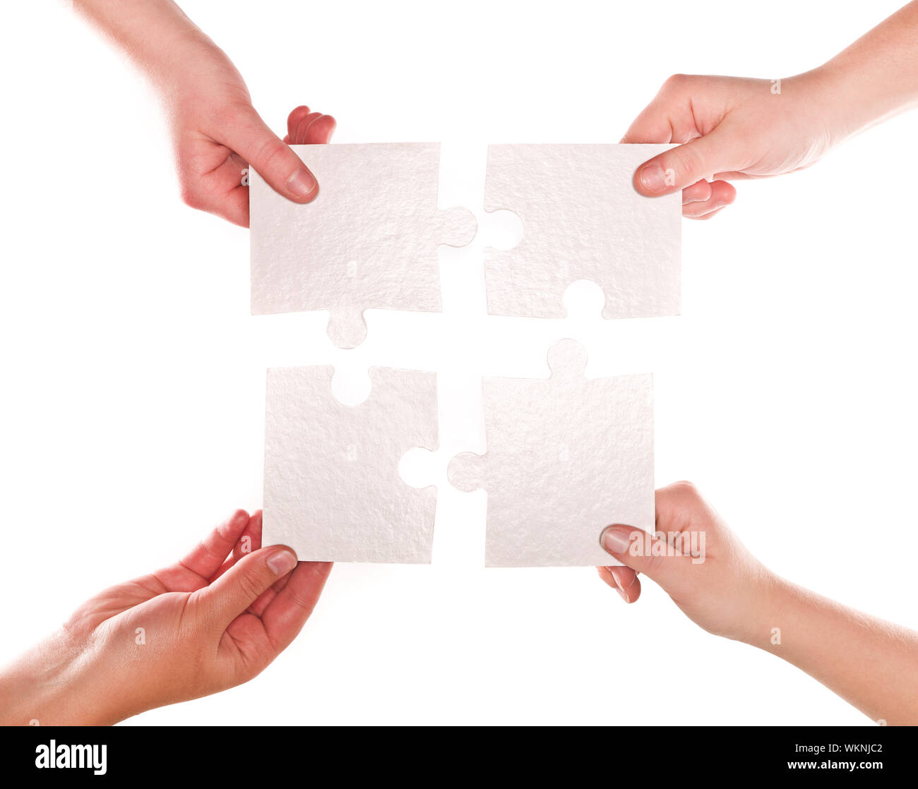 Four human hands with puzzle pieces connecting Stock Photo Alamy