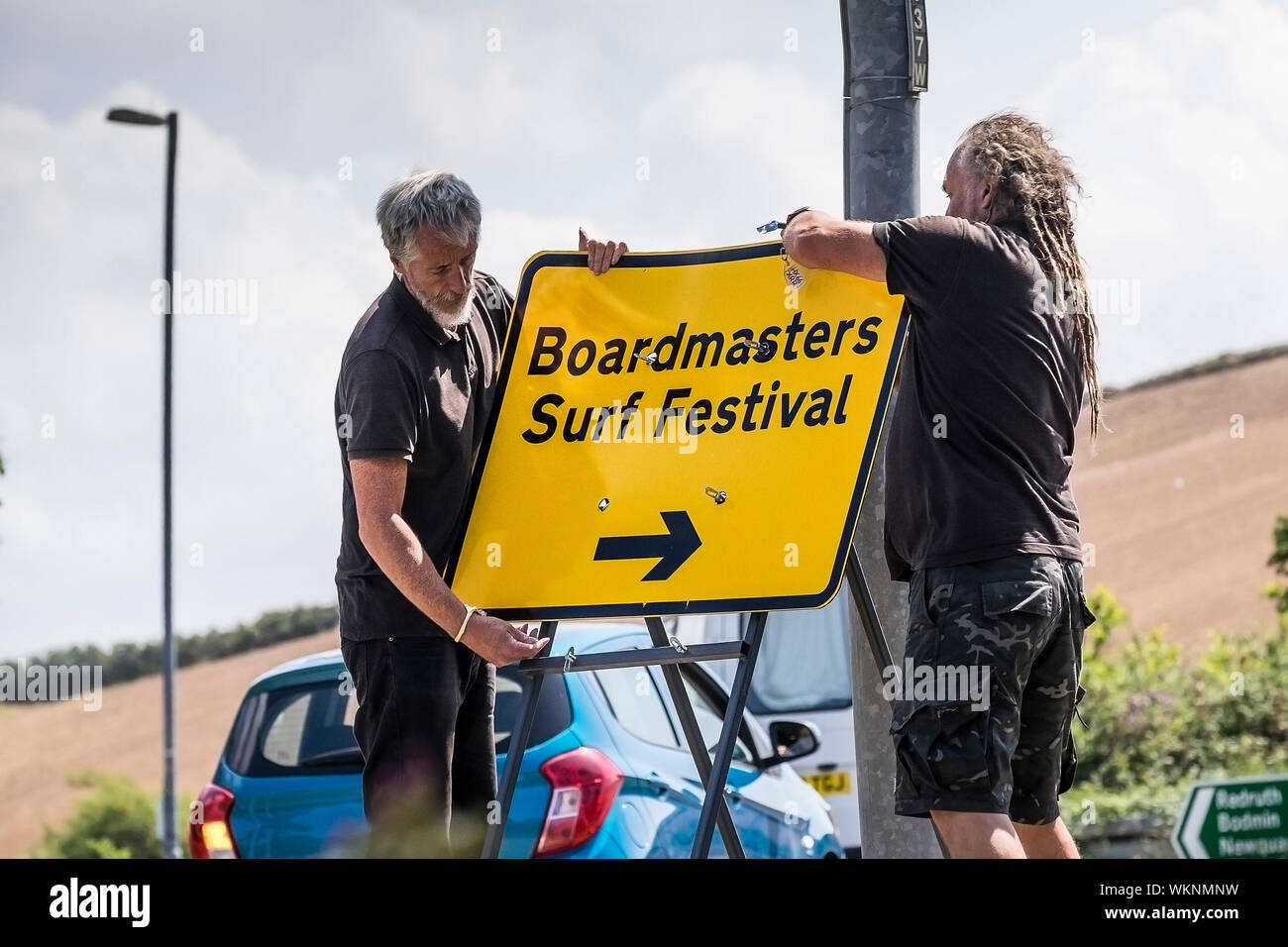 Workers erecting a sign for the Boardmasters Surf Festival in Newquay in Cornwall. Stock Photo