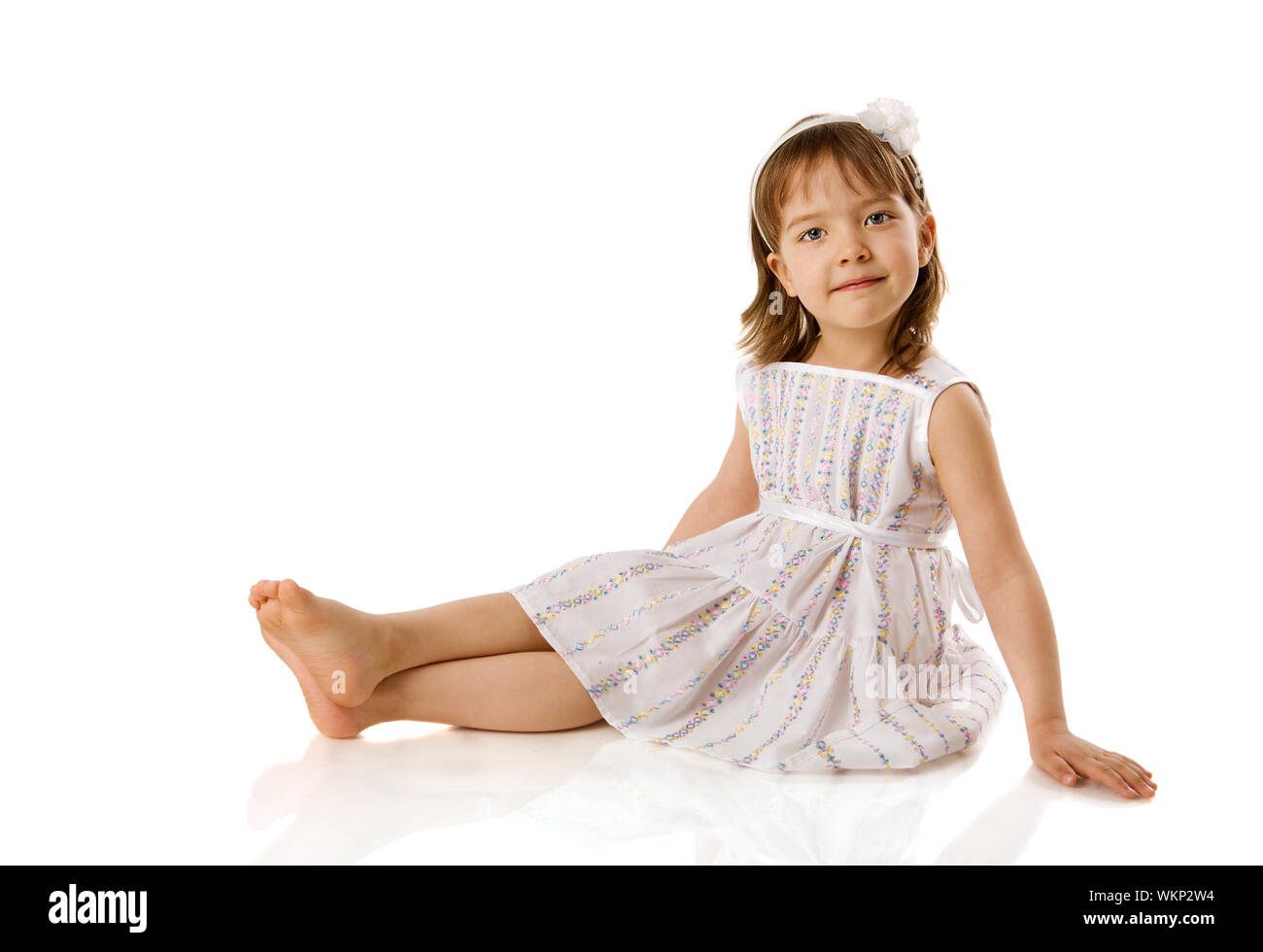 Happy Little girl sitting isolated on white Stock Photo