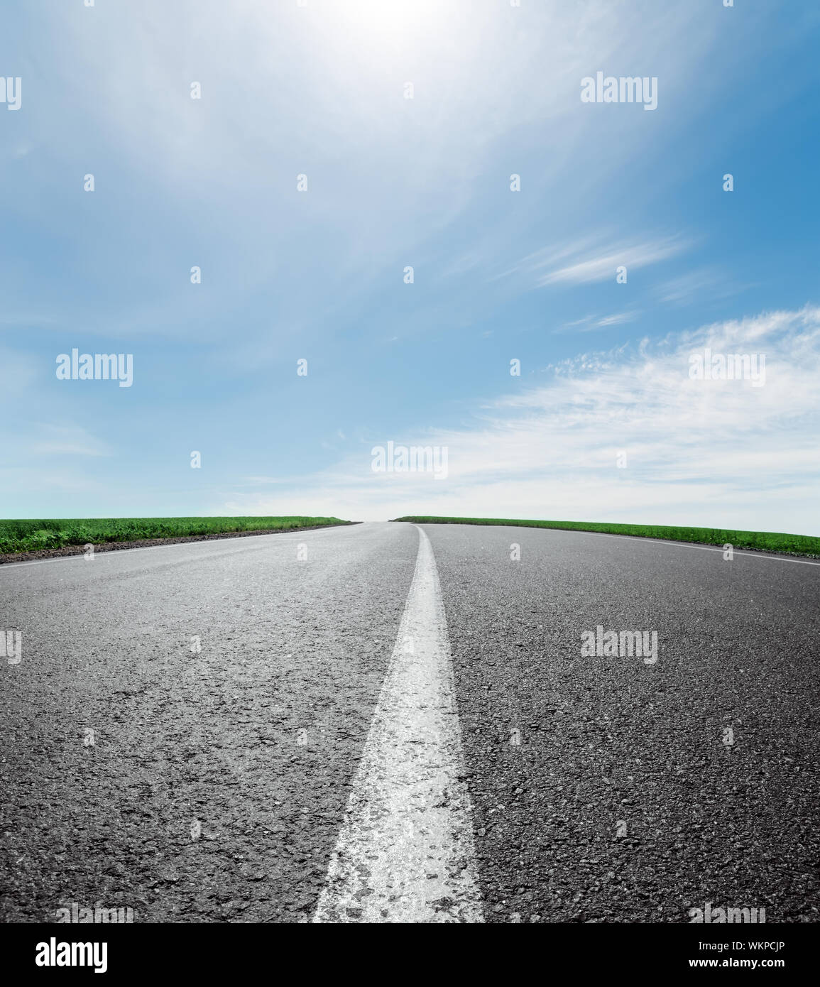 asphalt road to horizon under sky with clouds and sun Stock Photo - Alamy