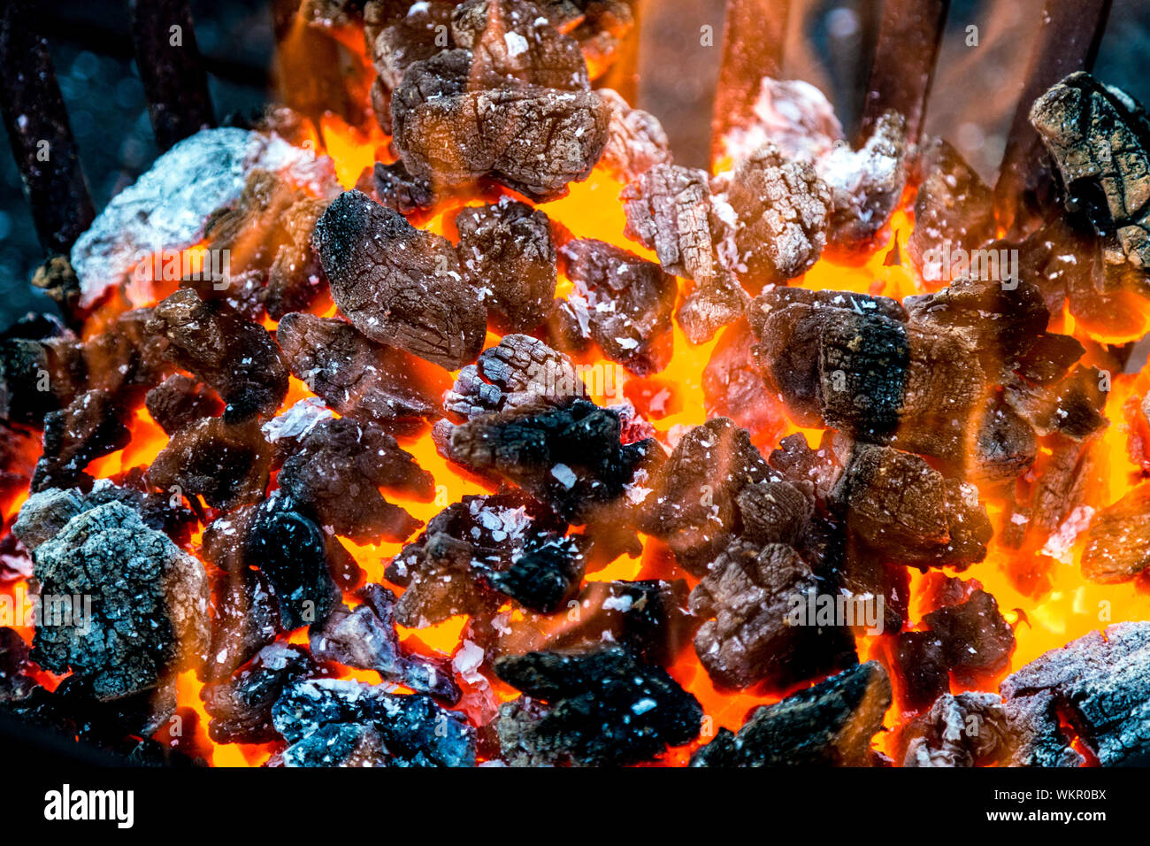 Glowing charcoal in a metal fire basket Stock Photo